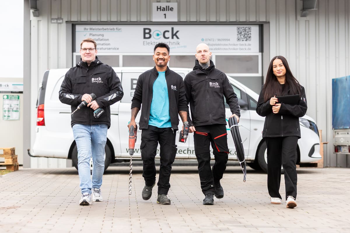 Drei Mitarbeiter mit Werkzeug auf dem Weg zum Einsatz